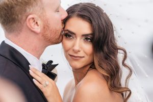 Intimate wedding portrait moment against a light colored background.
