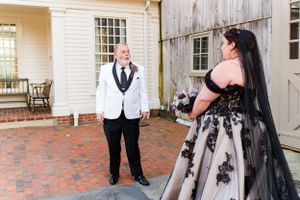 A dramatic black and white wedding dress contrasts beautifully against the rustic venue setting.