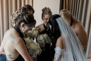 Wedding party embraces in an emotional group hug during a tender moment at the ceremony.