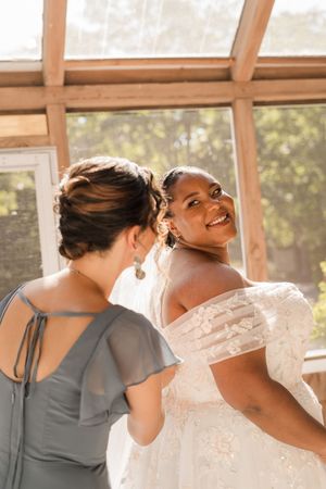 A series of candid wedding photos showing a bride and bridesmaid in gray dress sharing joyful moments together.