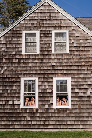 Progressive sequence of cedar shake house windows showing people appearing in different frames against blue sky.