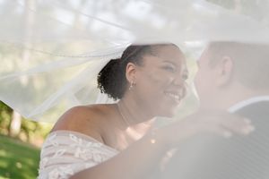 A bride and groom share a joyful moment during their outdoor wedding ceremony.