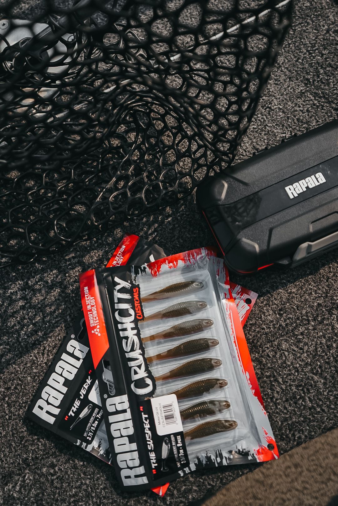 Rapala fishing tackle and gear packages arranged on a textured dark surface.