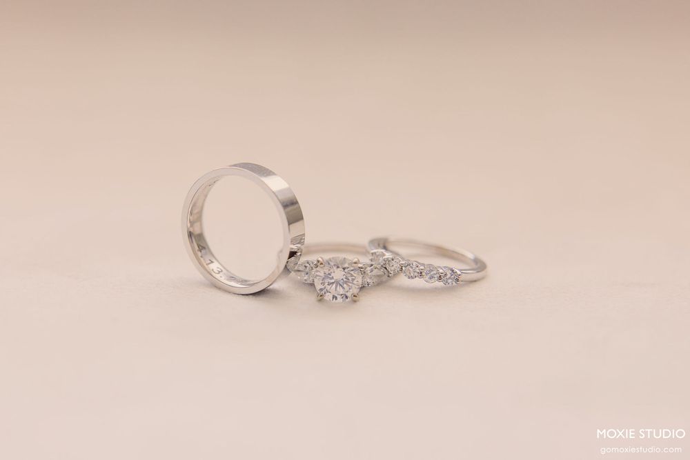 Three elegant engagement rings with diamonds in white gold or platinum settings displayed on a soft beige background.