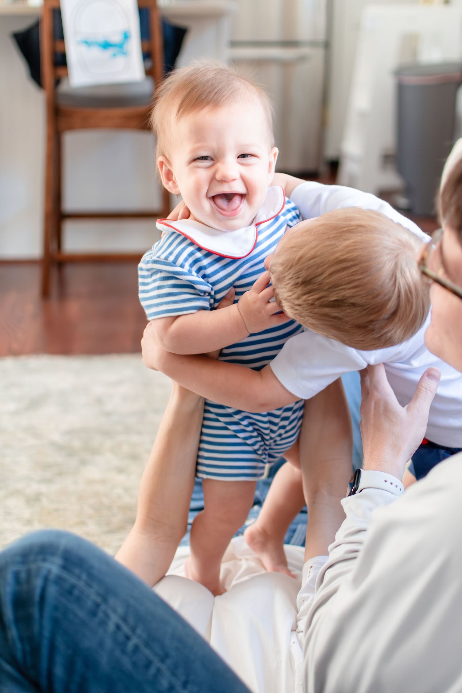 A young Ardmore family playfully snuggles together on the couch in their living room.