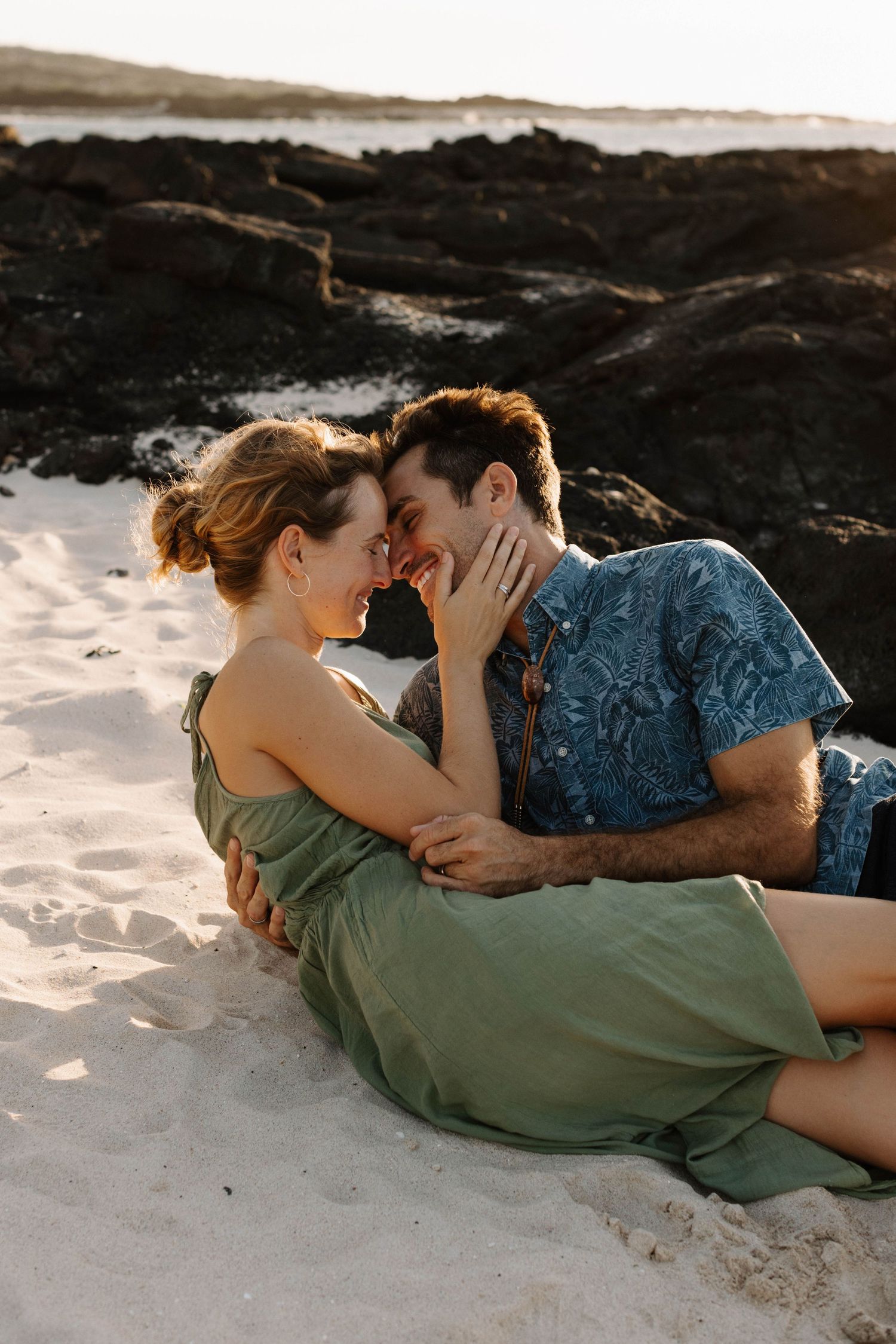 Romantic beach scene with couple sharing an intimate moment at sunset.