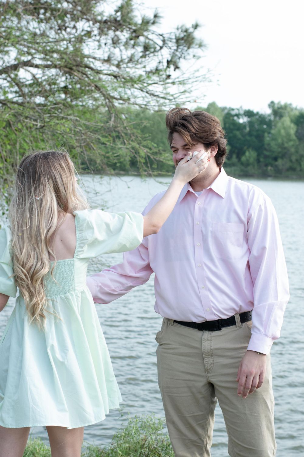 A romantic moment by the lakeside with a couple in pastel outfits.