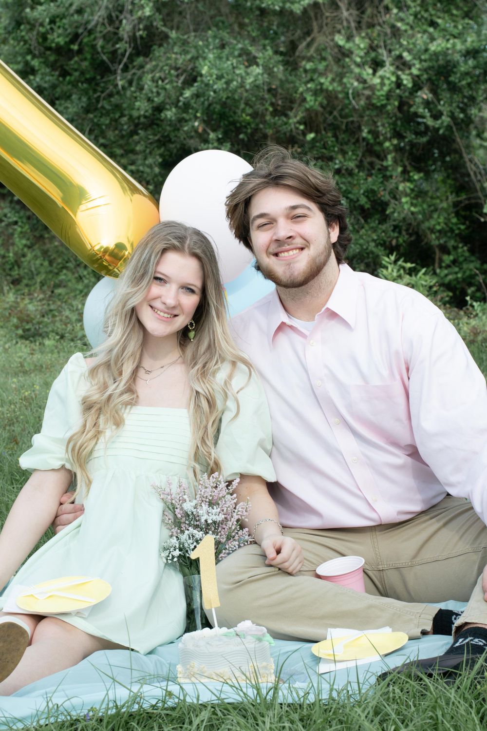 Picnic scene with gold balloon, blue blanket, and mint green dress.