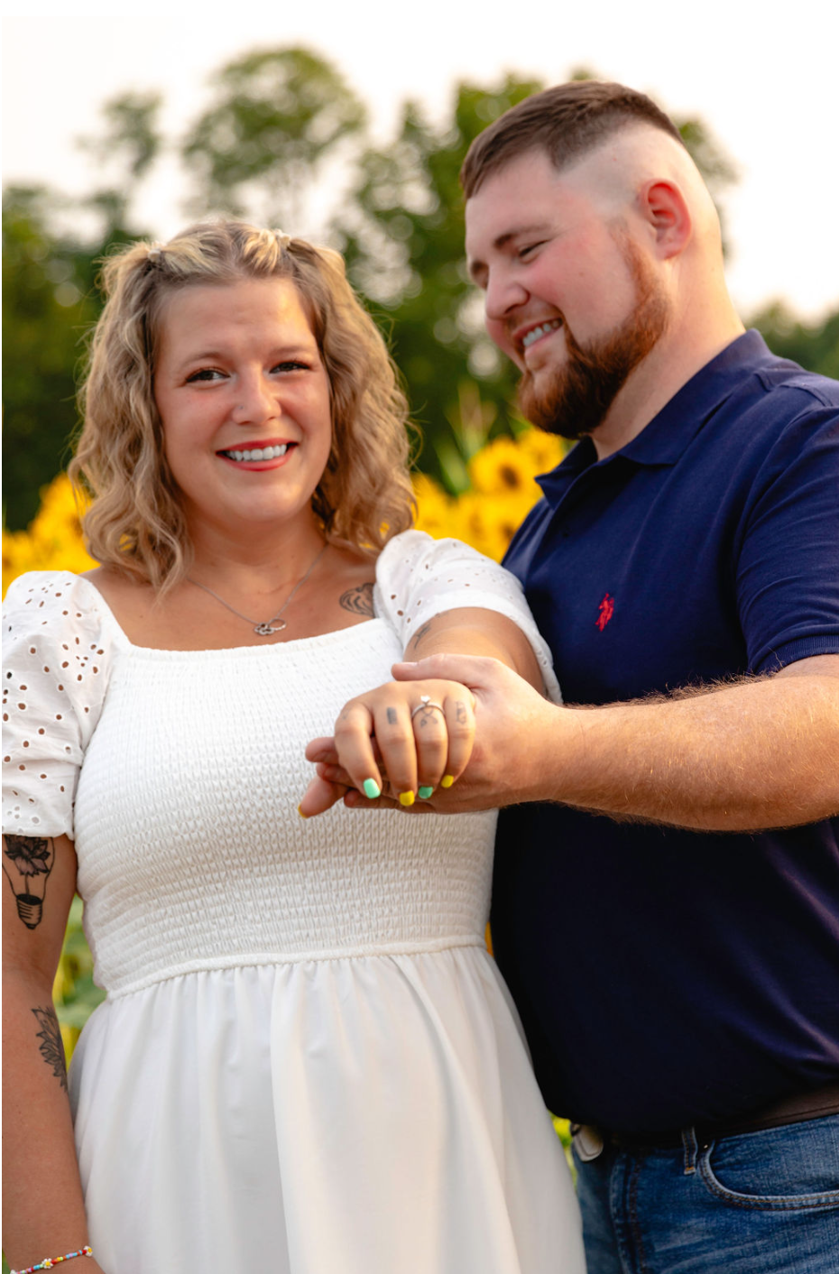 engagement photo in a sunflower field with bride showing ring