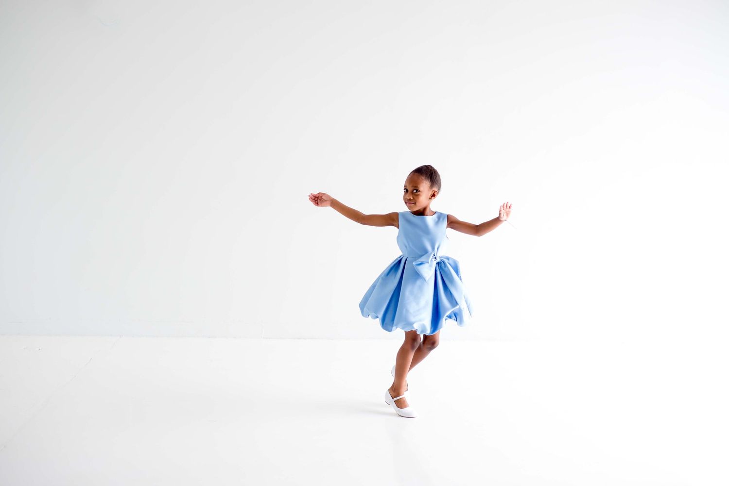 african american girl dancing in a white all natural light studio