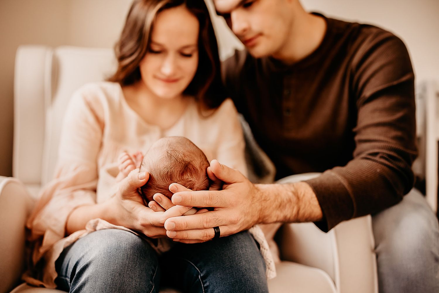 Parents sit in their son's nursery holding his head in their hands.