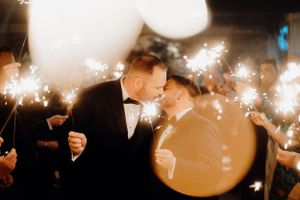 Romantic sparkler exit with newlyweds sharing an intimate moment among glowing lights.