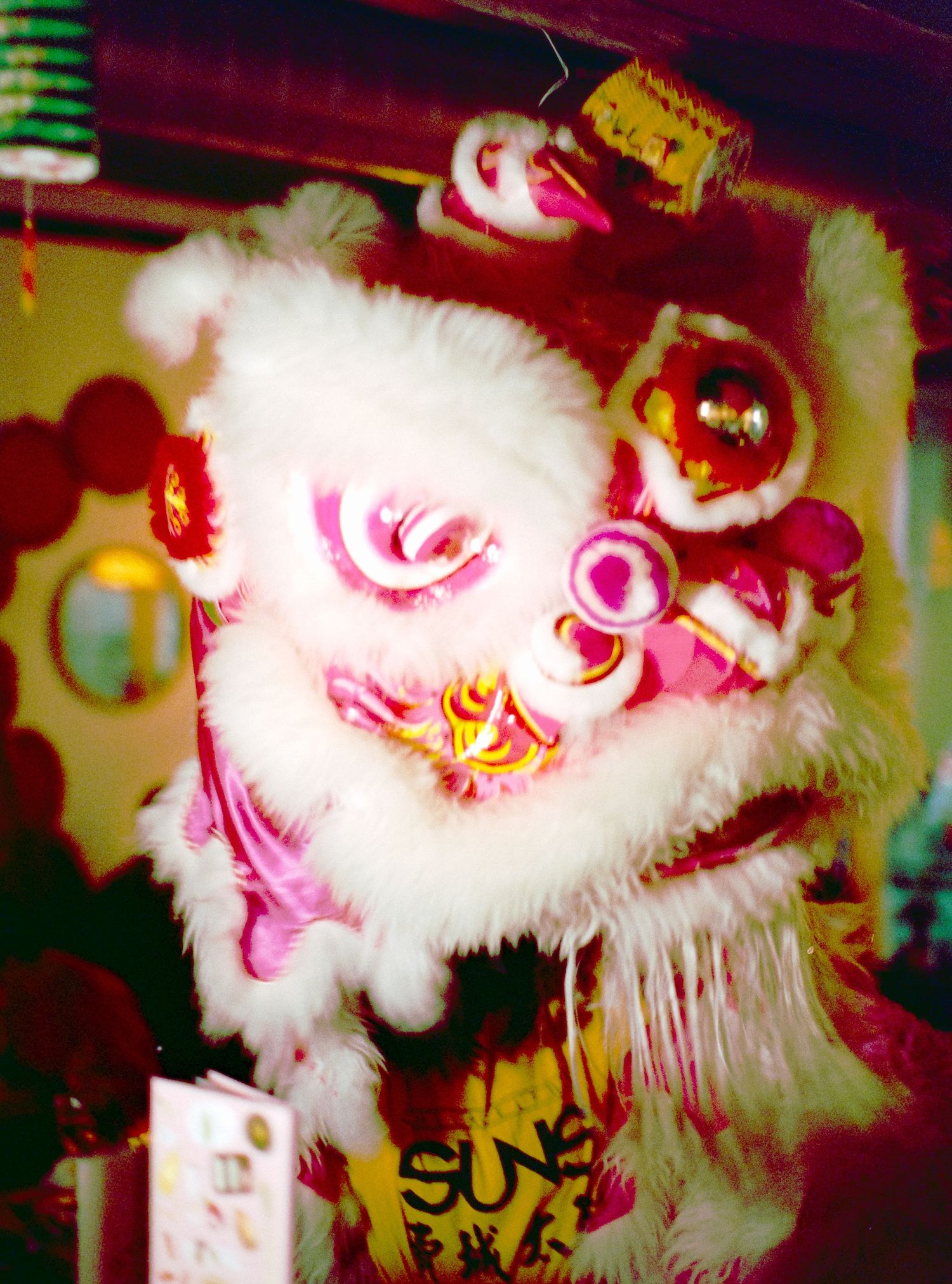 Traditional white Chinese lion dance costume head with red decorative elements.