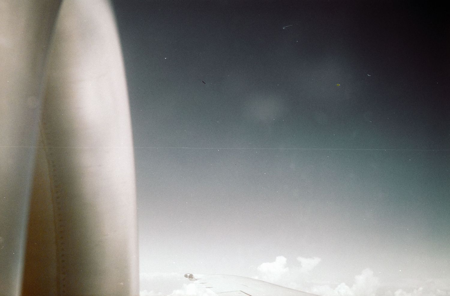 Abstract close-up view of white structure against blue sky with clouds.