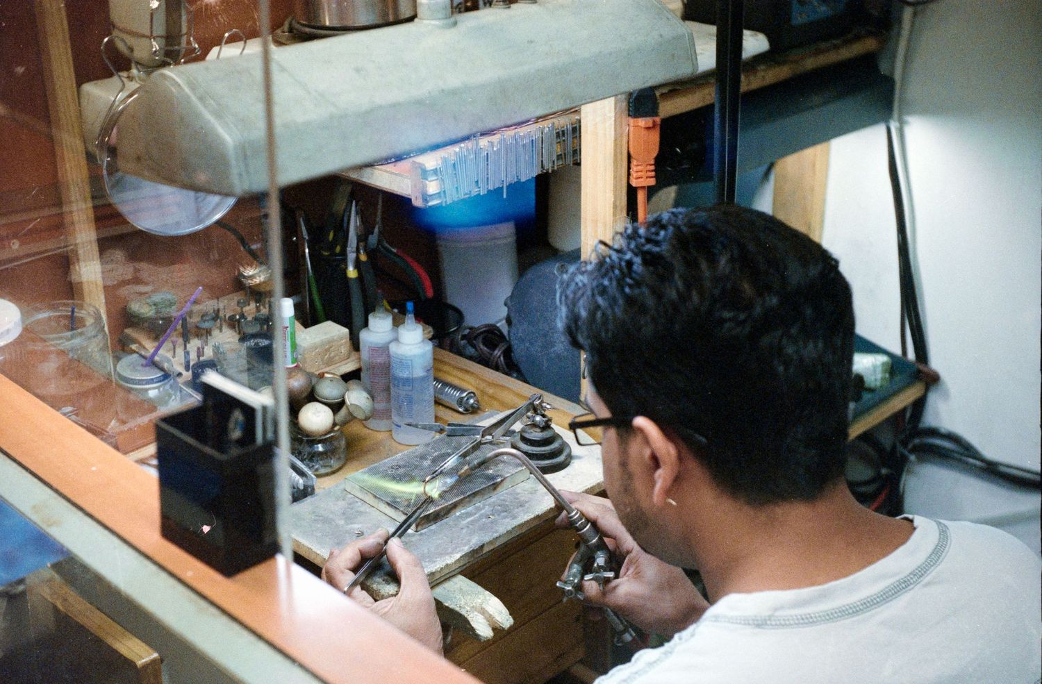 Laboratory technician working at desk with microscope and scientific equipment.