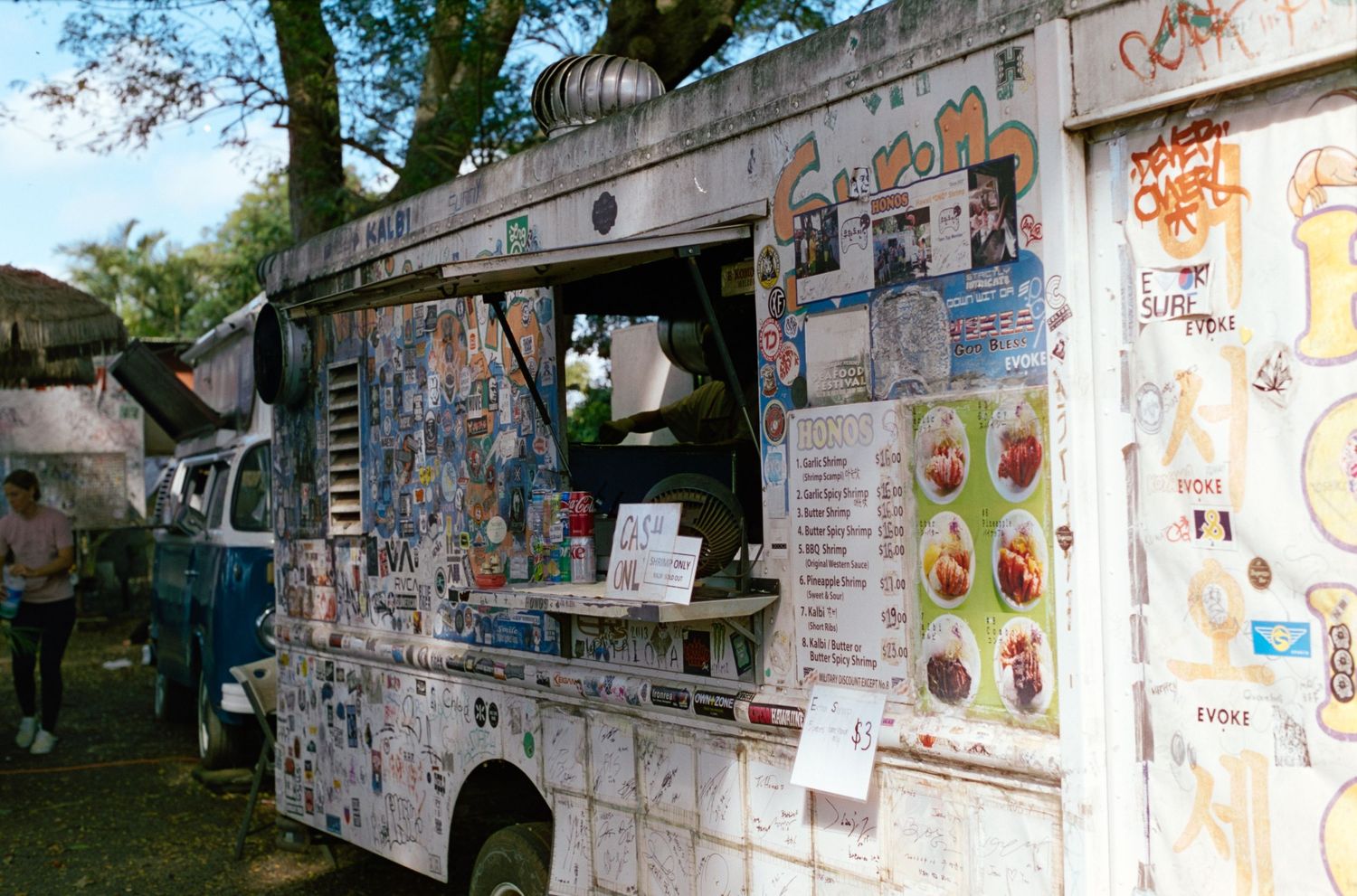 White food truck with menu items displayed on the side panel.