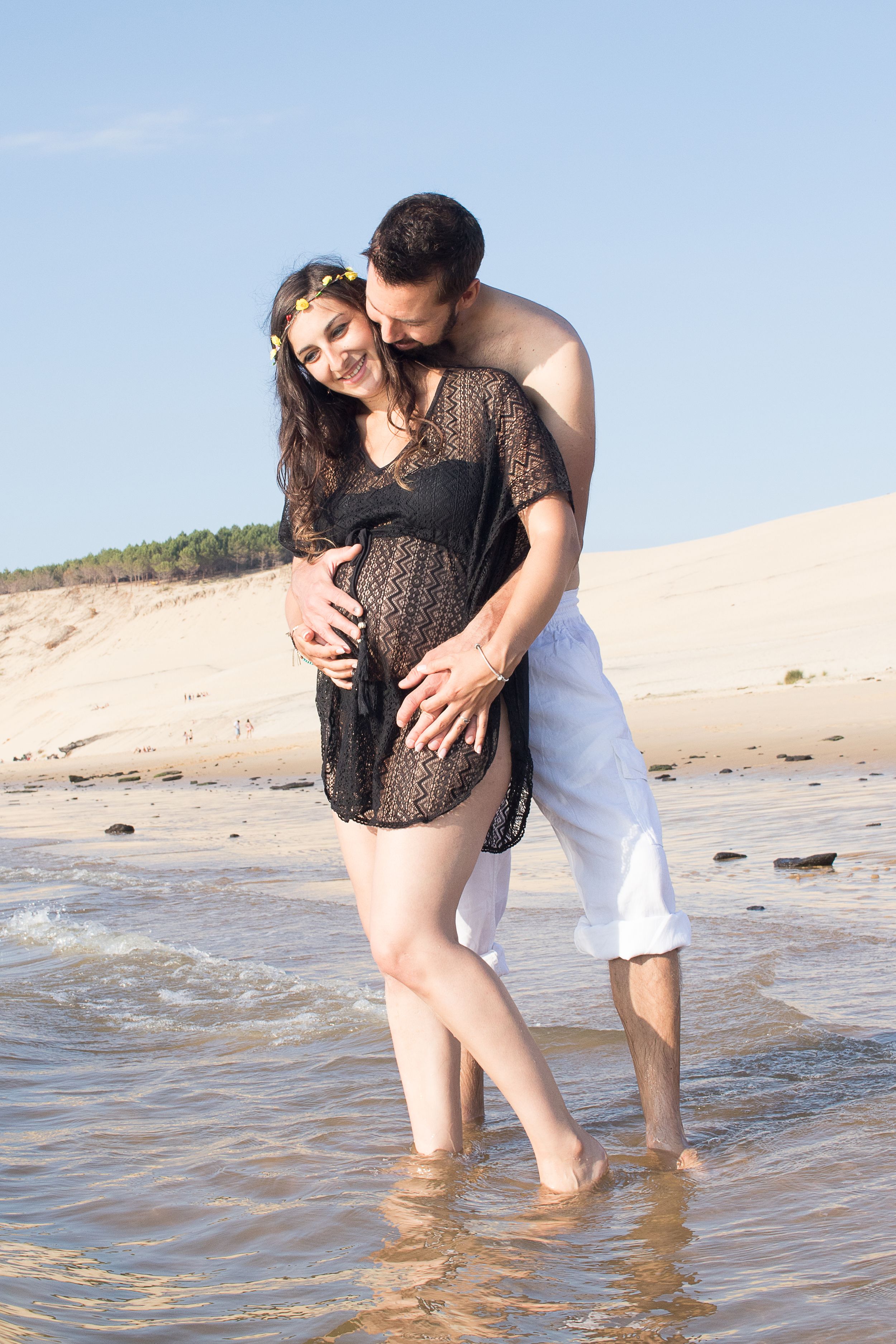 mujer embarazada y su pareja a la playa
