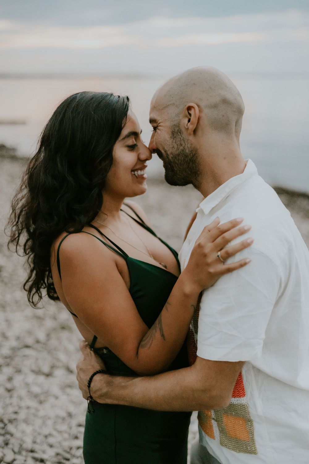 A close intimate moment between a couple on a beach during golden hour.