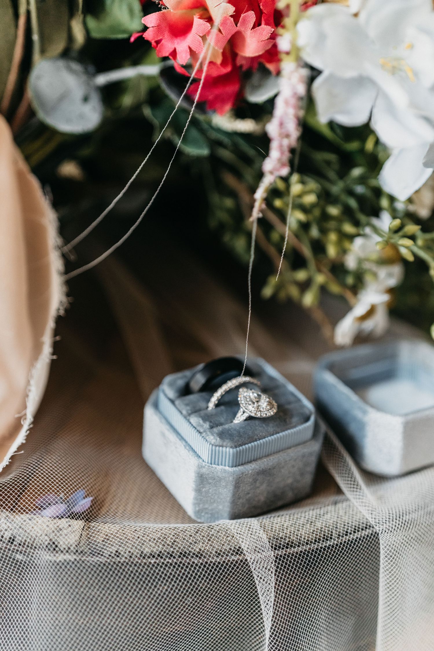 Flat lay detail shot of wedding rings, veil and bridal bouquet