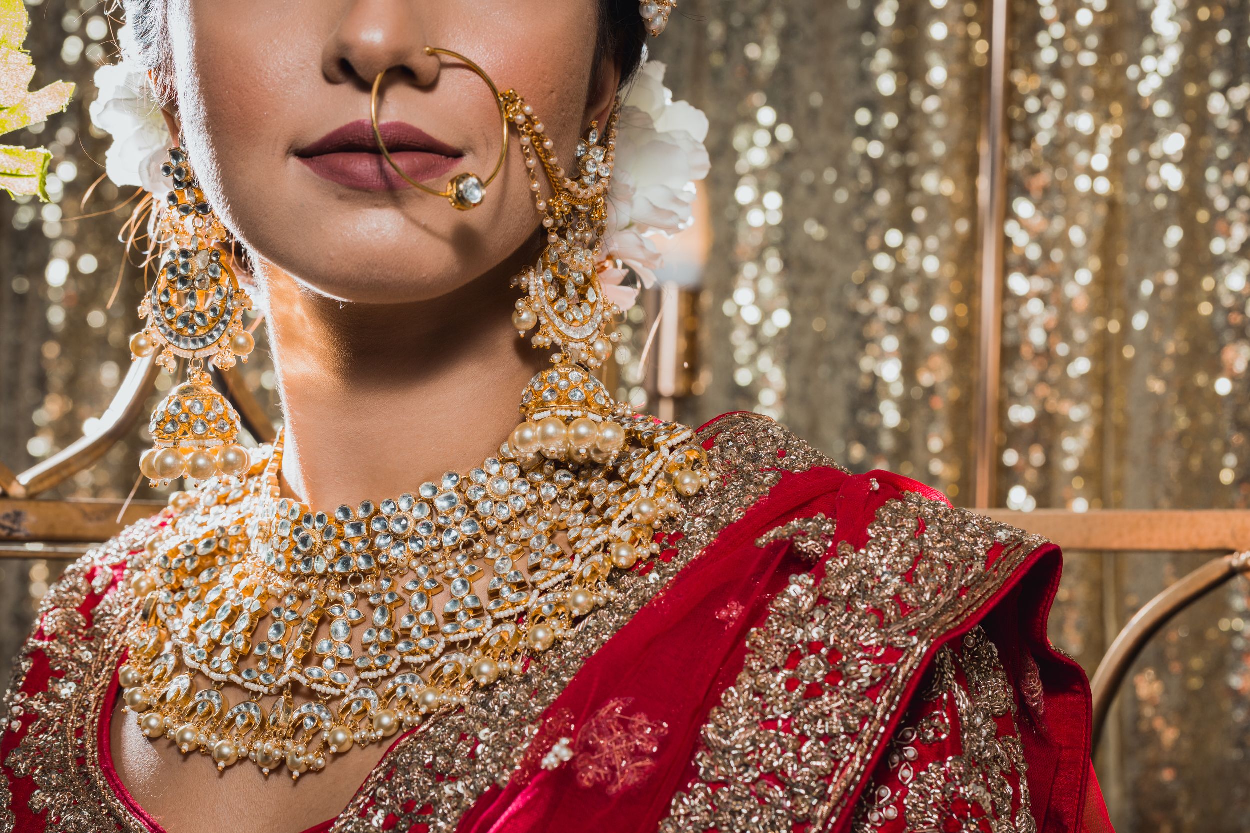 Close-up shots of traditional Indian wedding jewelry and bridal details against a gold sequin backdrop.