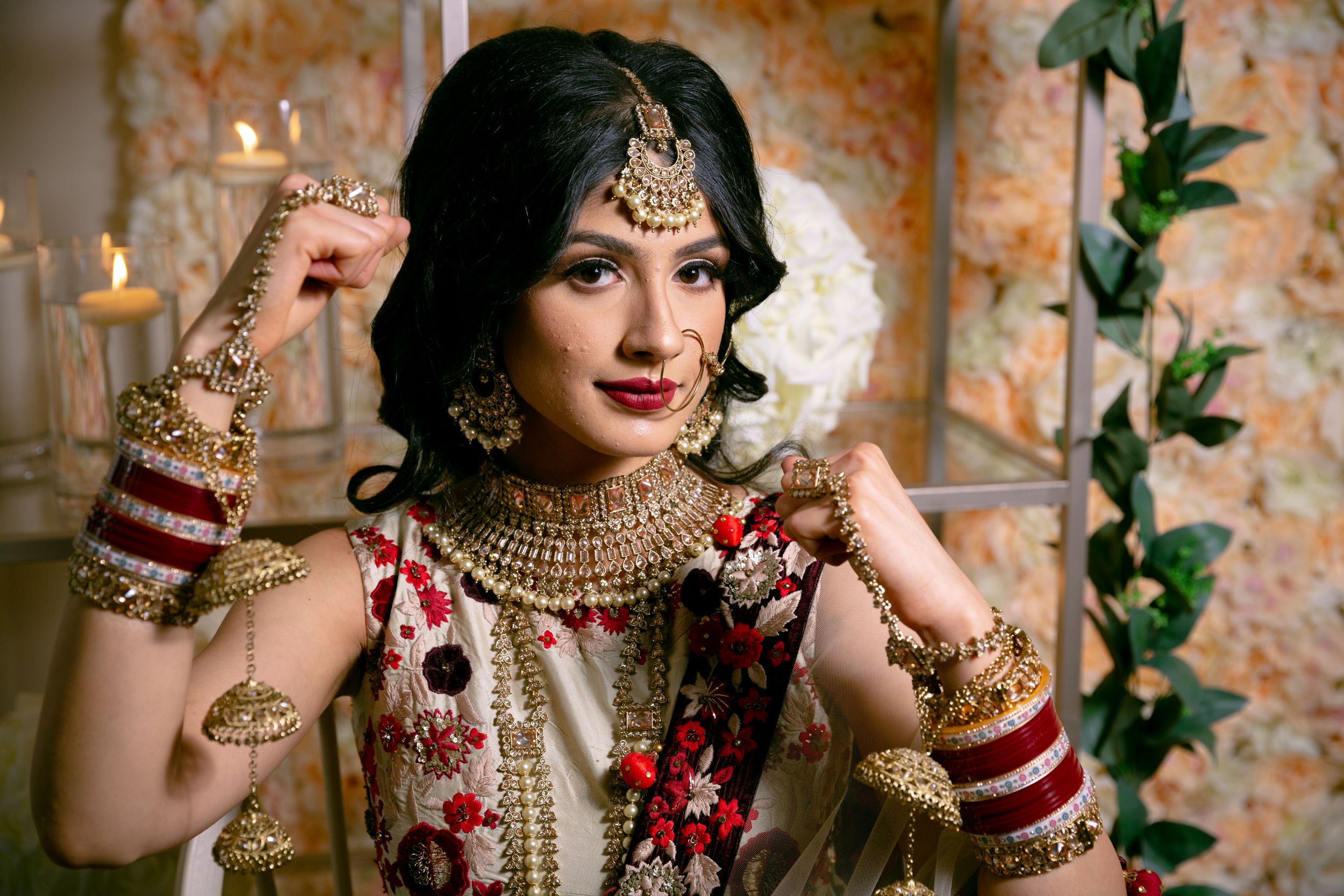 Artistic bridal portraits featuring traditional Indian jewelry and red attire against floral backdrop.