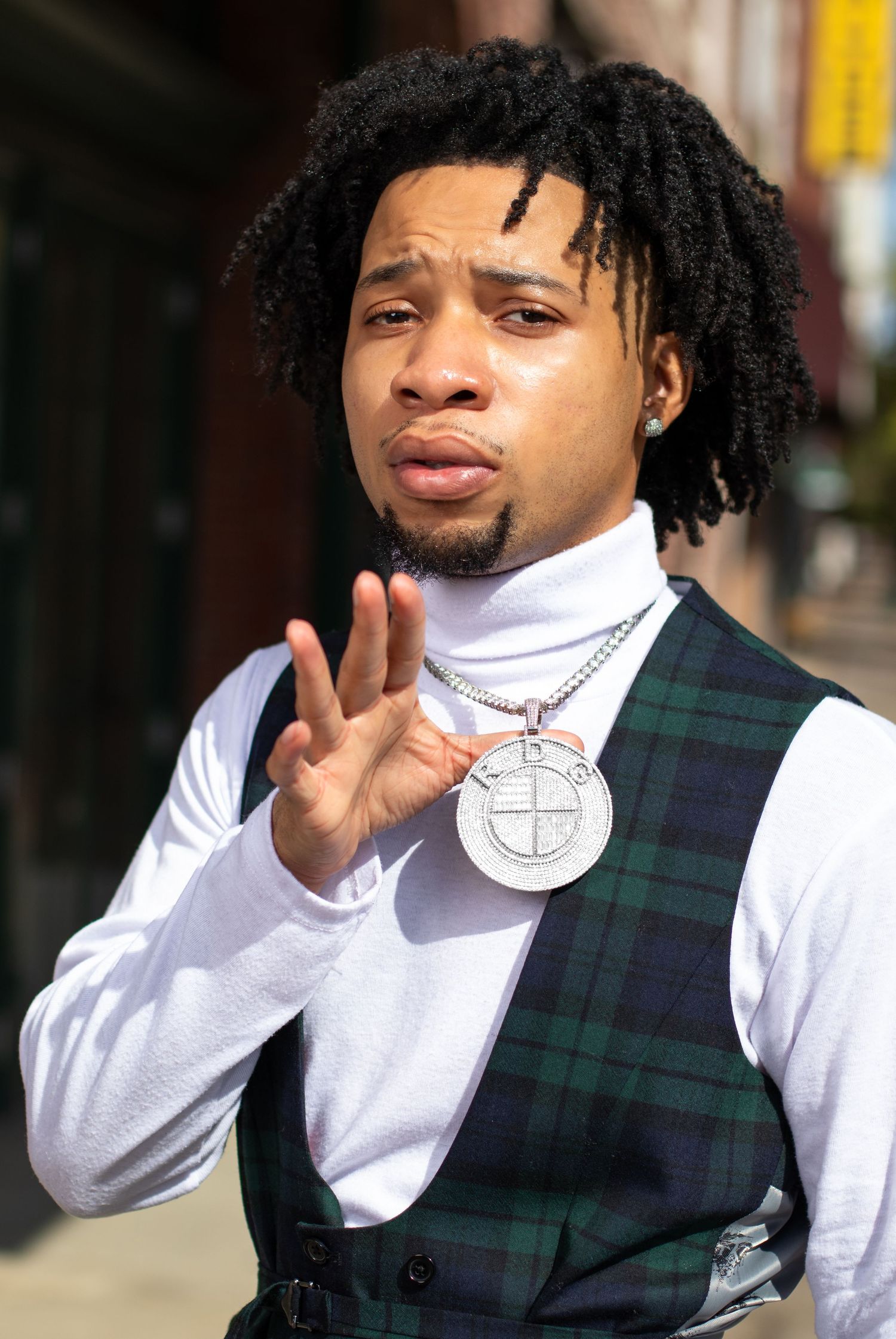 Portrait of a man holding his medallion in front of the Alabama Theater.