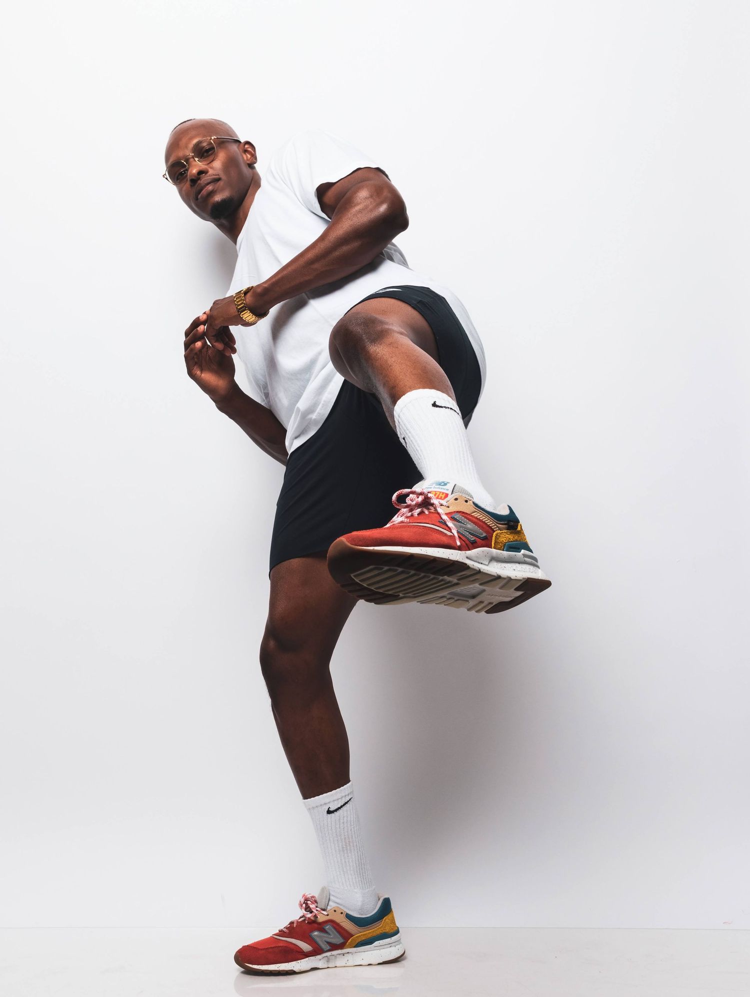 Athletic figure in white shirt and black shorts demonstrating dynamic stretching pose.