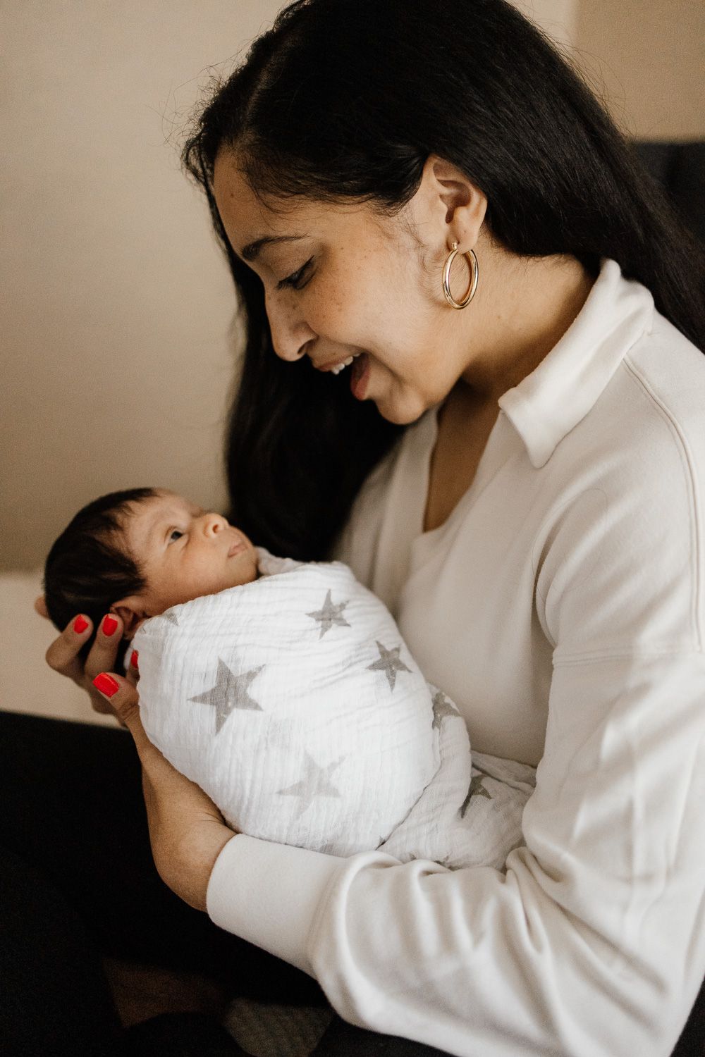 Mother holding swaddled baby at in-home lifestyle newborn photoshoot in Campbell by Newborn Photographer Cindy Tucey