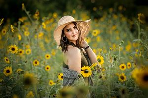 young woman standing in sunflower field Greenville Texas portrait photographer