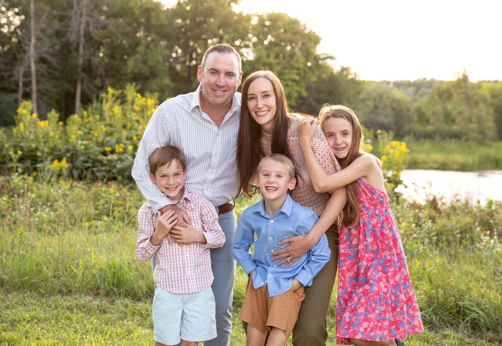 Happy group portrait outdoors in natural setting during golden hour.