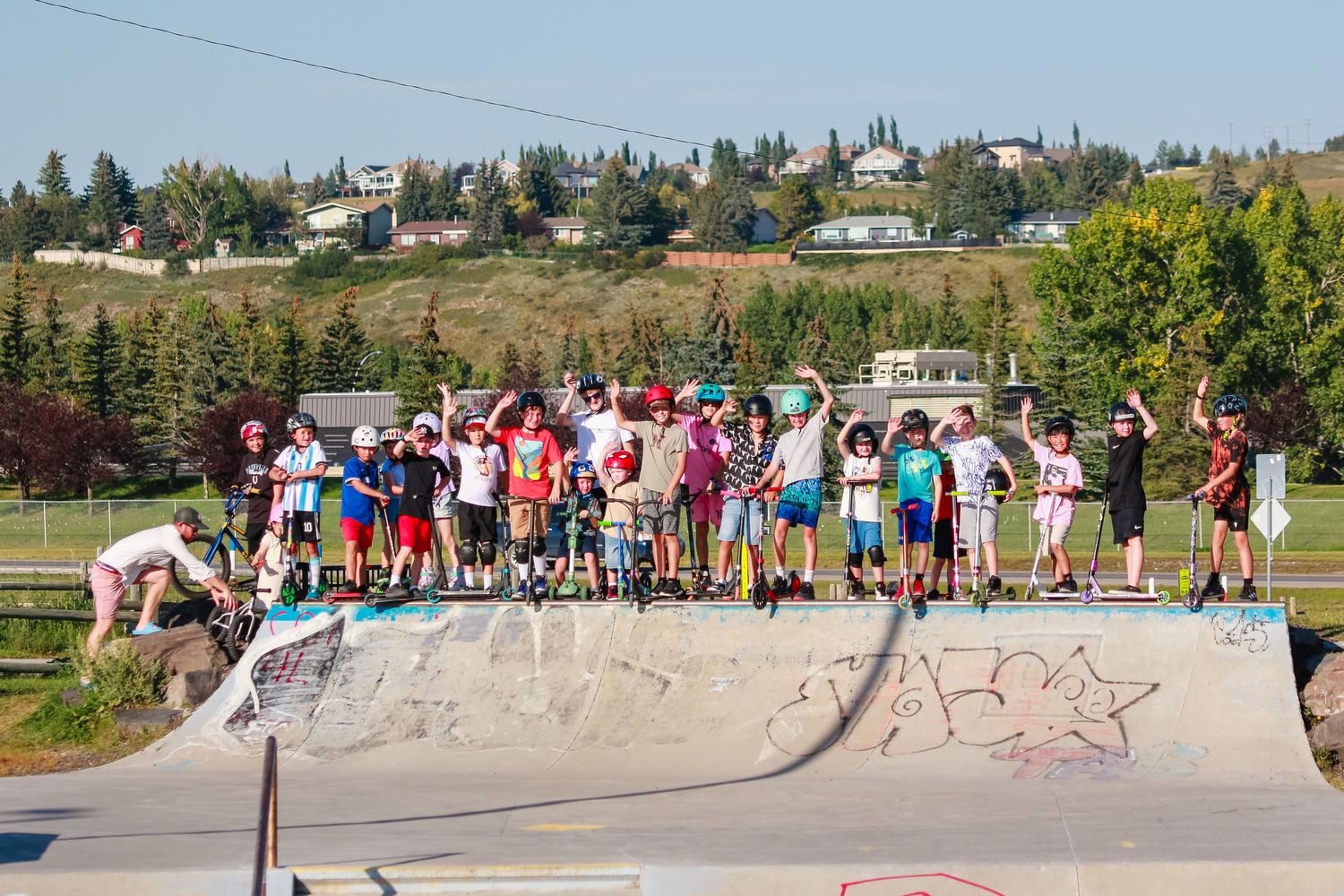 Group of children posing on a skate park ramp on a sunny summer day.