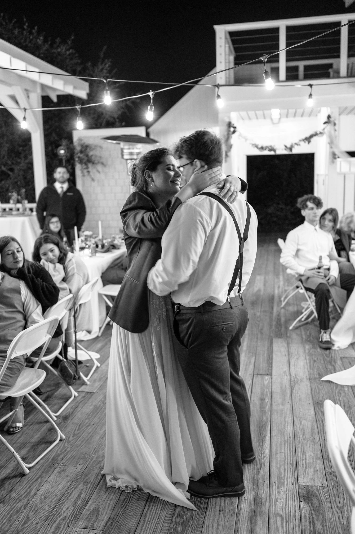 Black and white photos of wedding guests dancing on wooden deck at night reception.