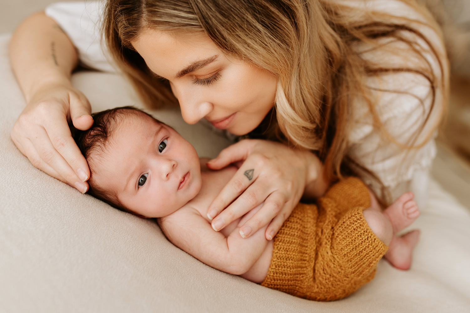 Lifestyle newborn photography session with soft neutral color palette.