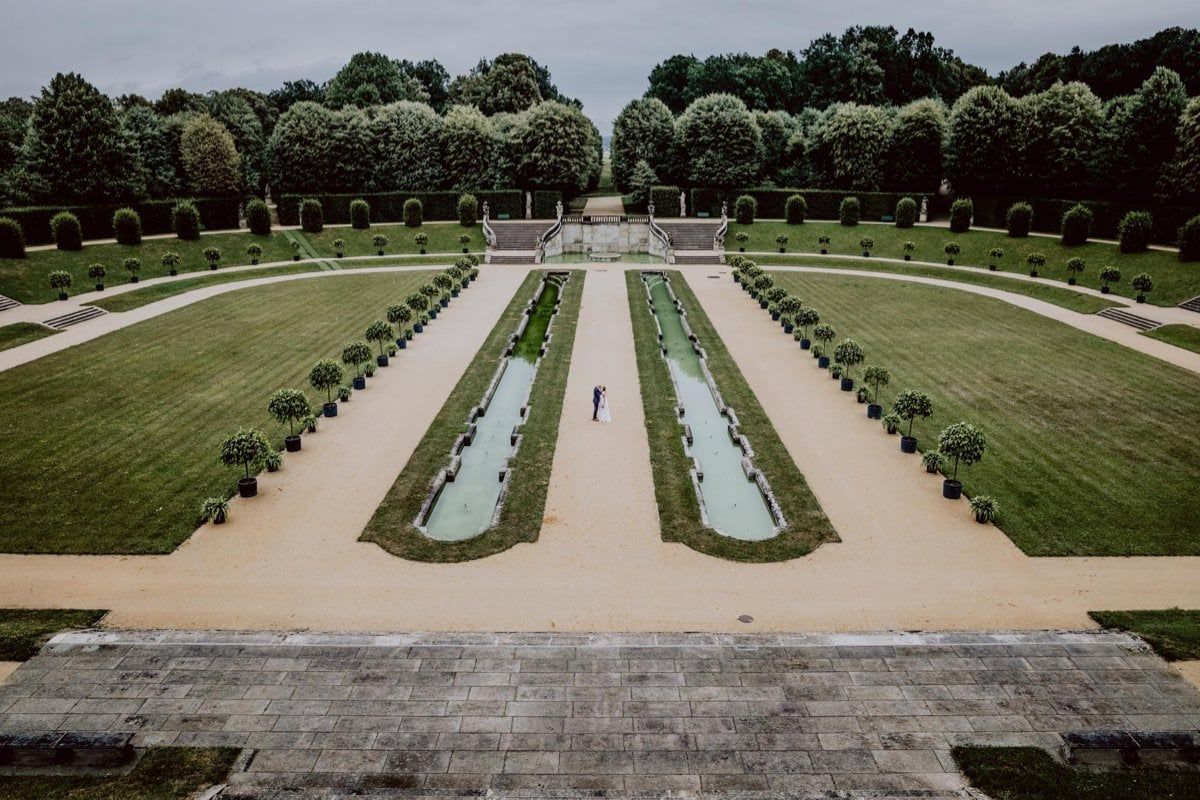 Symmetrical garden design featuring two reflecting pools flanked by manicured hedges. Organized wedding by MyCastleWedding | Dresden.
