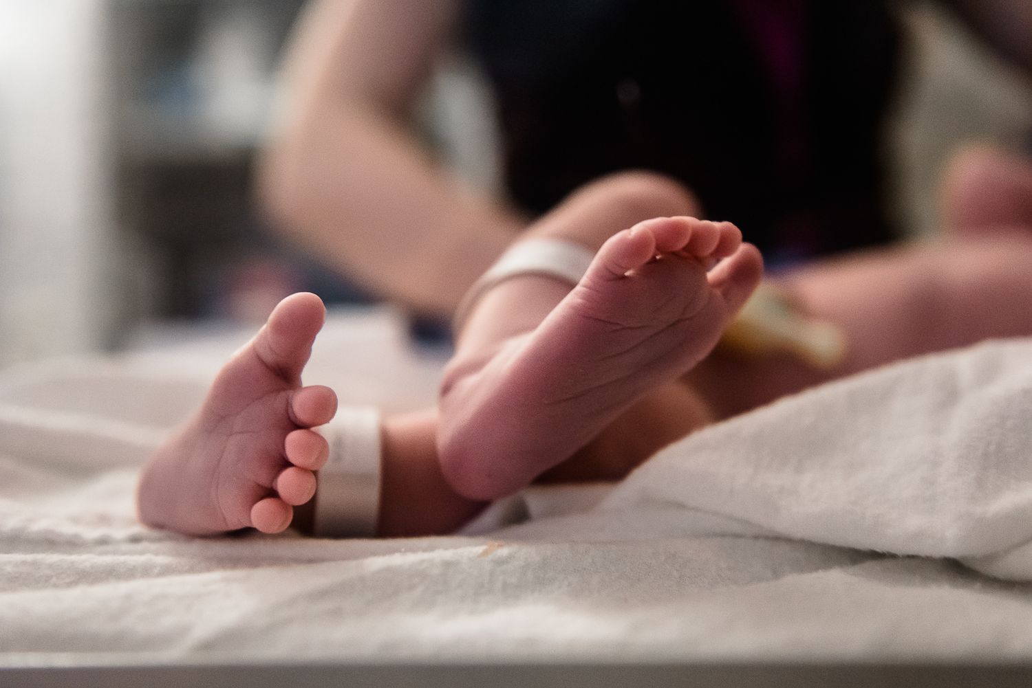 baby feet closeup with hospital bands on ankles