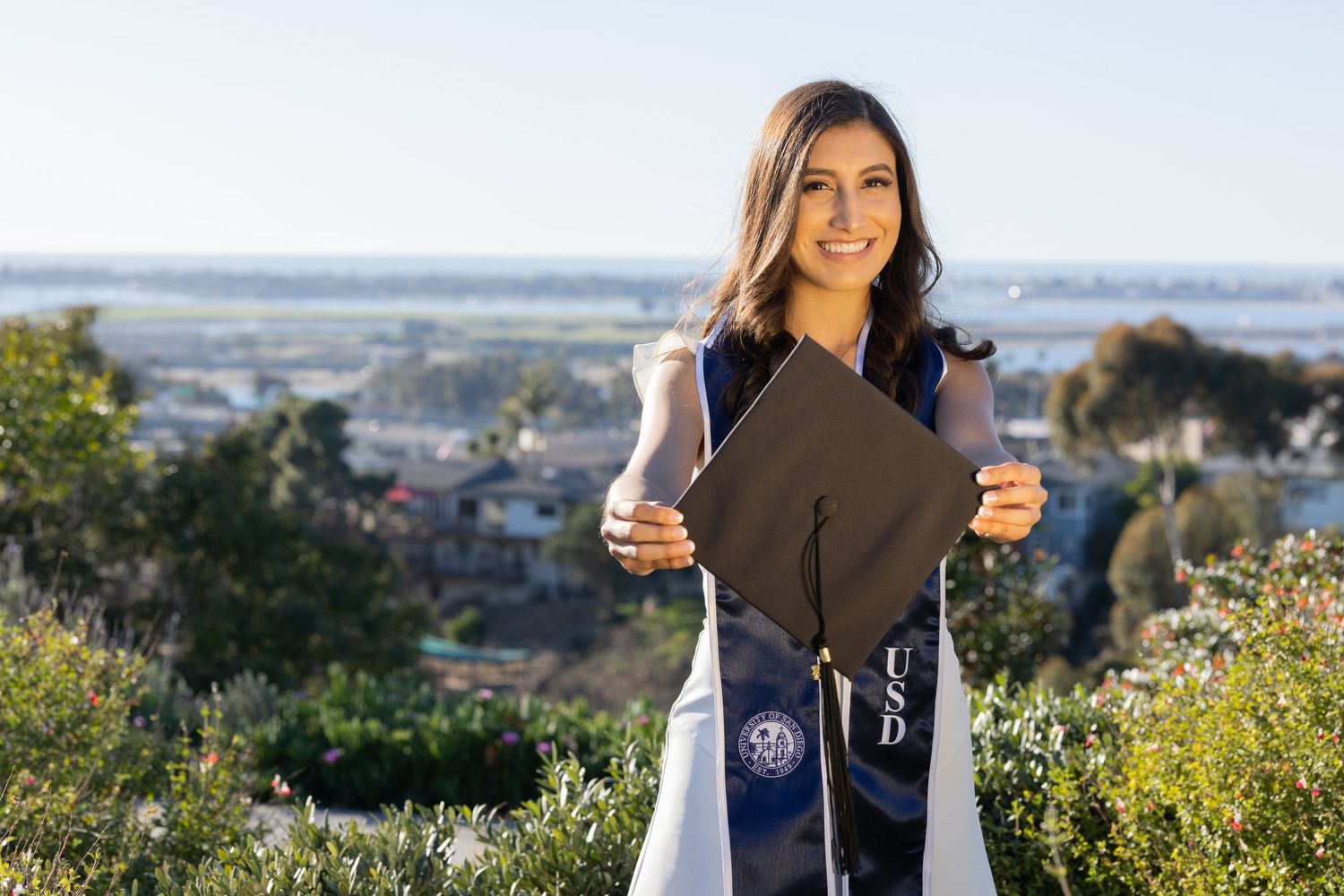 College graduate holding her graduation cap at University of San Diego