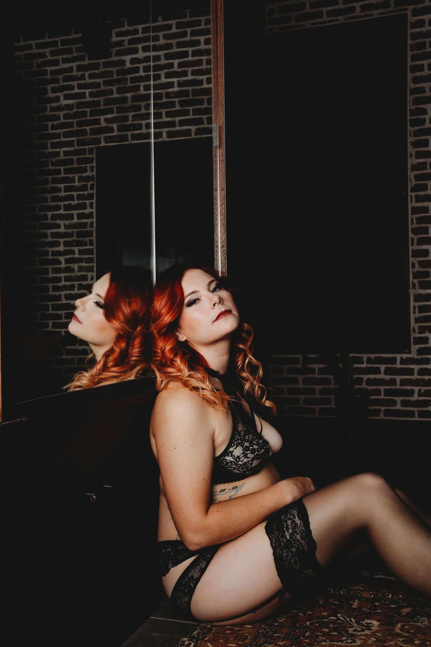 Sensual photography series against exposed brick wall with intimate lighting.