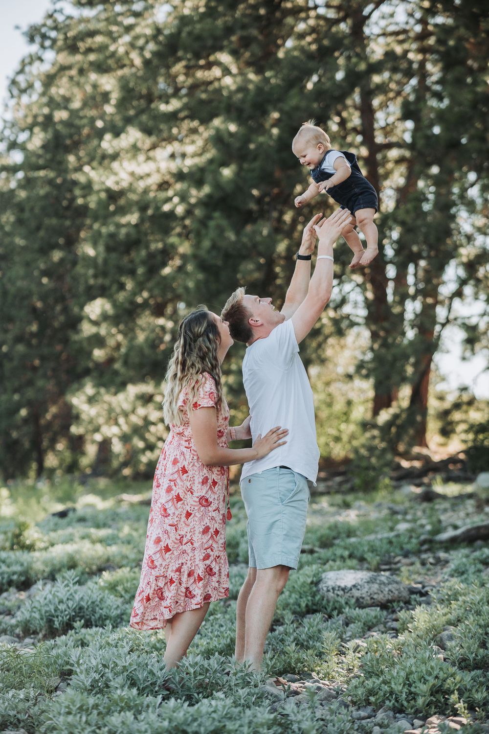 A proud couple lift their newborn son, capturing a tender family moment filled with love and happiness.