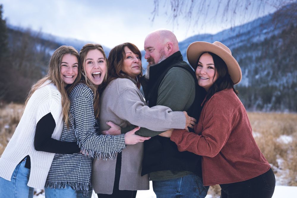 A joyful family embraces each other in a snowy landscape, surrounded by white snowflakes and a serene winter atmosphere.