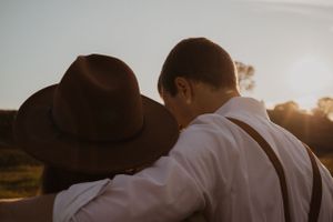 A romantic sunset photoshoot in a golden field with warm glowing light.
