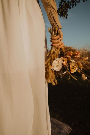 White fabric drapes elegantly against a rustic wooden backdrop in golden sunlight.