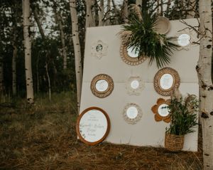 Rustic wedding decor display featuring vintage mirrors and greenery against an aspen forest backdrop.