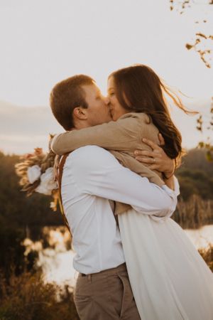 Tender embrace captured in warm autumn light with neutral tones.