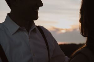 Silhouettes of people against dramatic sunset sky.