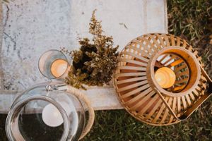 Overhead view of place settings with woven chargers and candles at sunset.