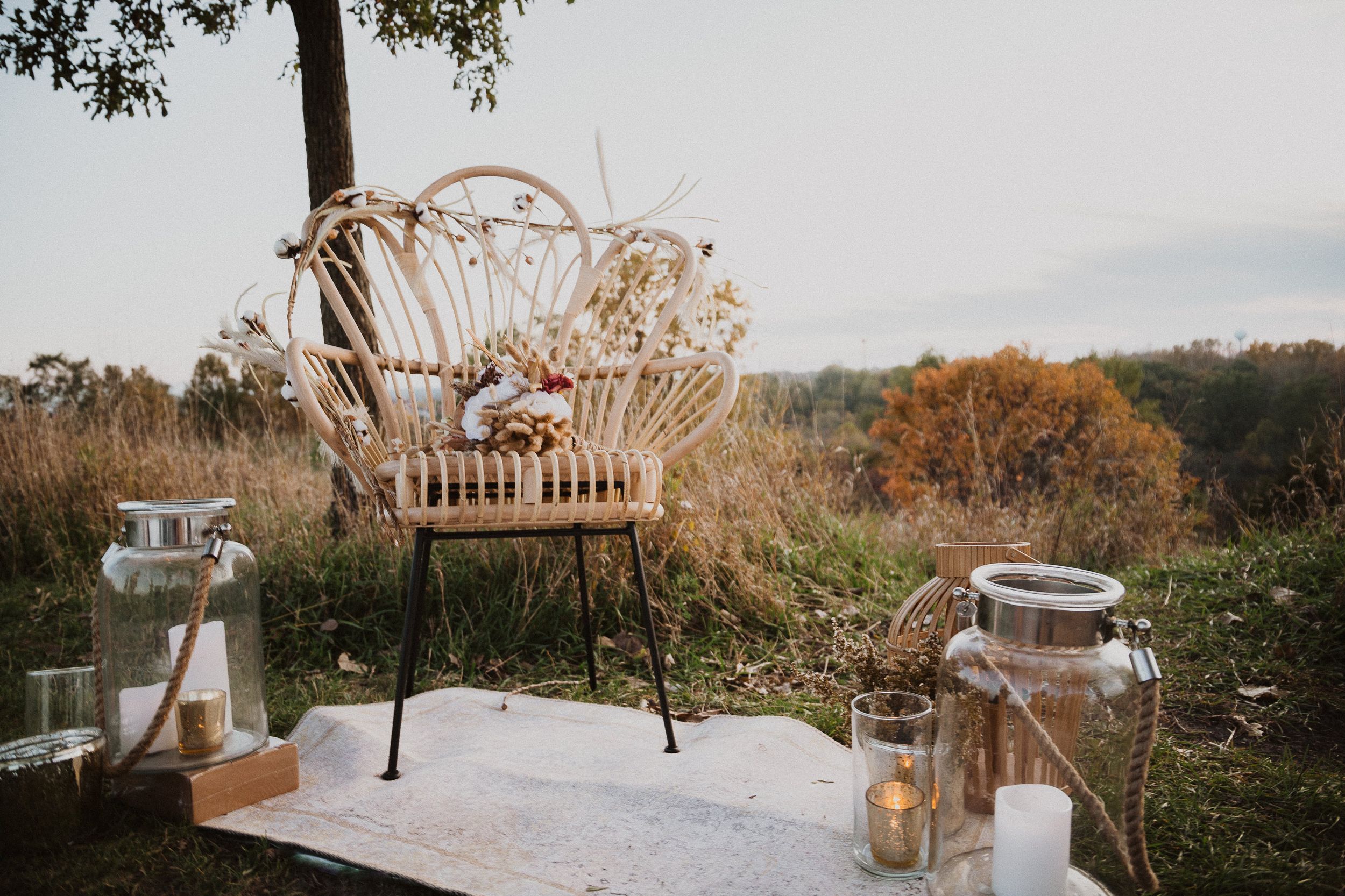 Outdoor dining setup with woven chairs and lanterns at golden hour.