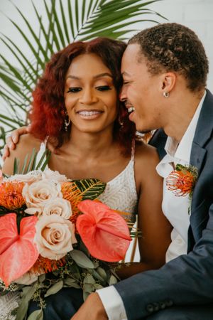 Wedding portrait with coral and blush floral bouquet featuring anthurium and roses.