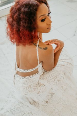 Close-up of a bride wearing a detailed lace wedding dress with delicate straps.