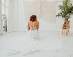 Bride and groom share a romantic moment in an all-white minimalist space.