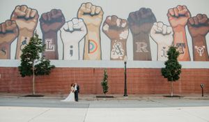 Urban wedding backdrop featuring a mural of raised fists and text art.